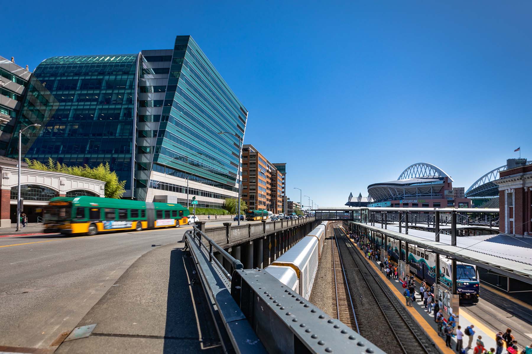 View along 4th Ave S of busses, Sounder train, 505 Union Station and stadiums