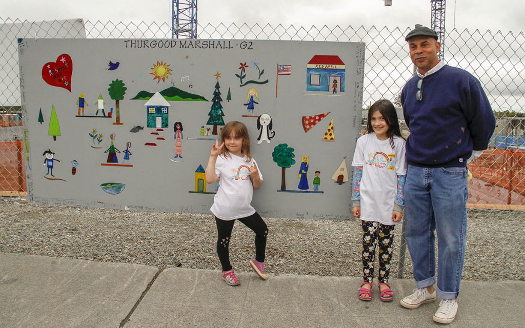 Lawrence Pitre with students in front of mural