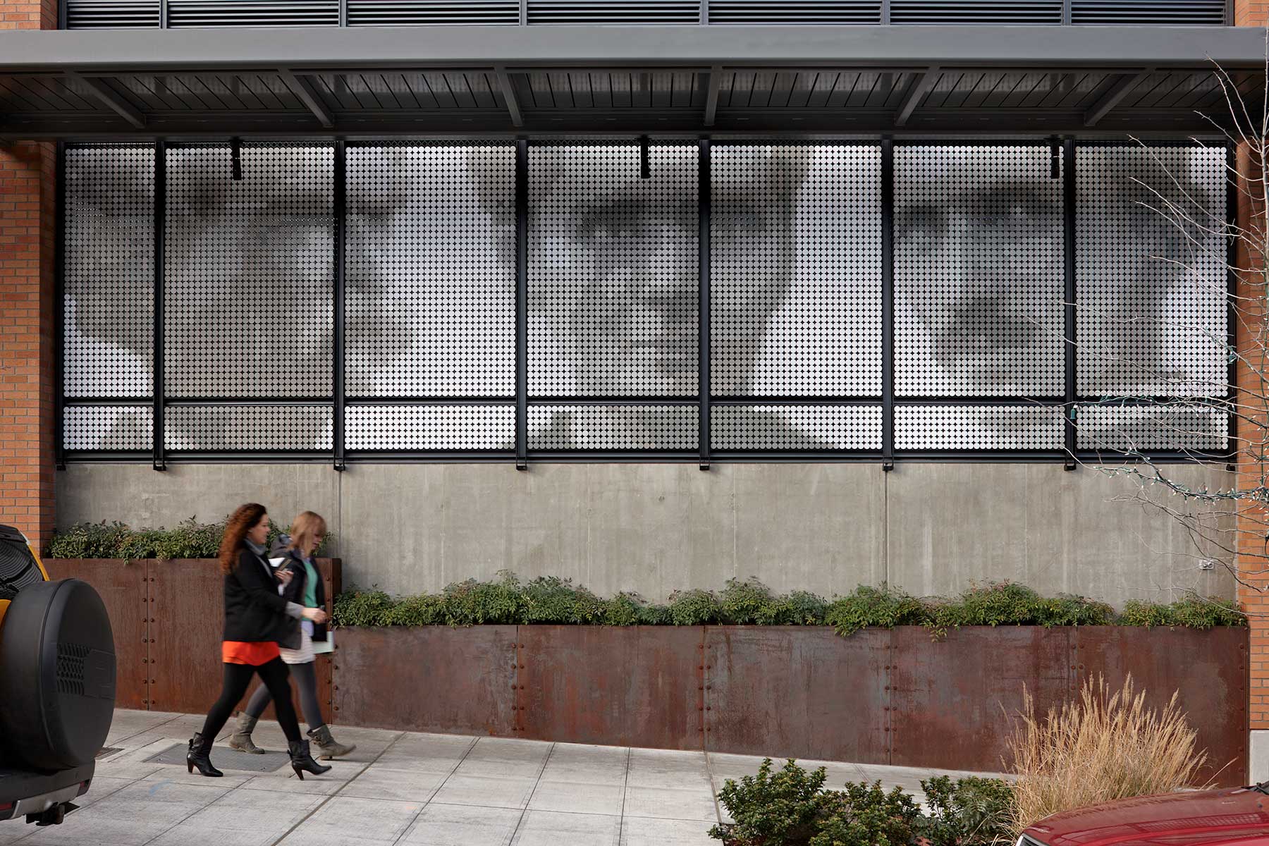 people walking by art in amz building window